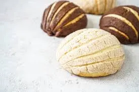 Chocolate and vanilla vegan conchas arranged on a clean light surface